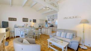 ein Wohnzimmer mit Sofa und Tisch in der Unterkunft Villa de plain pied avec jardin paysager et piscine in Ars-en-Ré