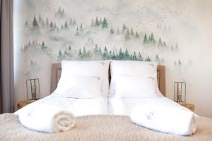 un letto con cuscini bianchi e un murale di alberi di Aloj Zakopane by Loft Affair a Zakopane