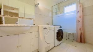 ein Badezimmer mit Waschmaschine und Waschbecken in der Unterkunft Villa de plain pied avec jardin paysager et piscine in Ars-en-Ré