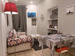 sala de estar con mesa y silla en Piazzetta dei Consoli Apartment, en Savona