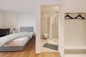 een slaapkamer met een bed en een badkamer met een douche bij Bären Herisau GmbH in Herisau