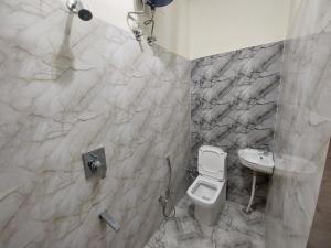 a bathroom with a white toilet and a sink at HOMEWOOD SUITES in Jaipur