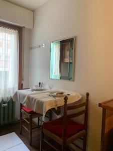 uma mesa com duas cadeiras e um espelho na parede em Casa Neve em Sestriere