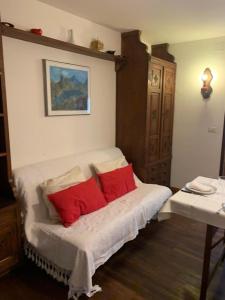 um quarto com uma cama com duas almofadas vermelhas em Casa Neve em Sestriere