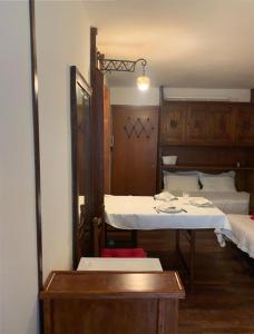 um quarto com duas camas e uma mesa em Casa Neve em Sestriere