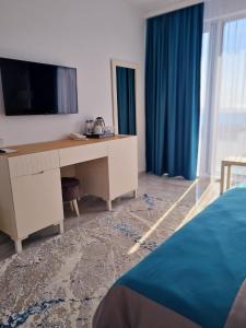 Meduza Hotel في أوليمب: غرفة نوم مع مكتب مع تلفزيون