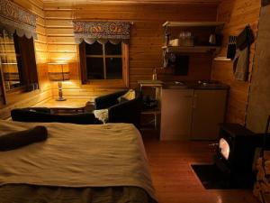 a bedroom with a bed and a living room at Northern Light Cabin with sauna by Torneriver in Kiruna