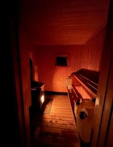 a dark room with a hallway with a bed and a stove at Northern Light Cabin with sauna by Torneriver in Kiruna