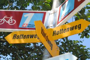 a street sign with yellow arrows on a pole at Hotel Nufenen in Ulrichen