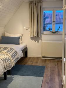 Schlafzimmer mit einem Bett und einem Fenster in der Unterkunft Home of gmiatlich - Ferien & Wohnen auf Zeit in Mühldorf