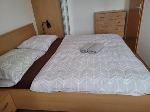 Una cama con un par de zapatillas encima. en Apartmán Neva Trnava, en Trnava