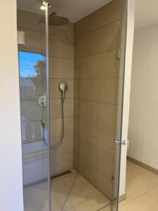 a shower with a glass door in a bathroom at Home of gmiatlich - Ferien & Wohnen auf Zeit in Mühldorf