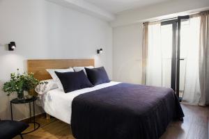 sypialnia z dużym łóżkiem z niebieskimi poduszkami w obiekcie Apartamento Bguest w Alicante