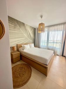 a bedroom with a bed and a large window at Villa Bruno con vistas al mar, primera línea de playa in El Cotillo