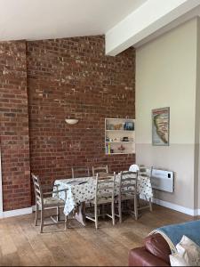 a dining room with a brick wall and a table and chairs at Strawberry Fields in Liverpool