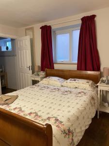 1 dormitorio con 1 cama grande y cortinas rojas en Strawberry Fields, en Liverpool