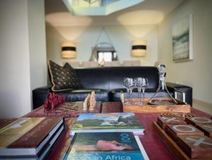 - une table avec des livres et des verres à vin dans l'établissement Calais Guest House, à Franschhoek