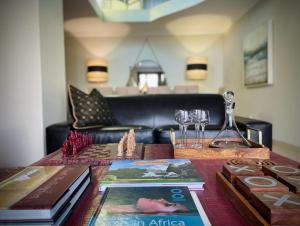 a table with books and wine glasses on top of it at Calais Guest House in Franschhoek