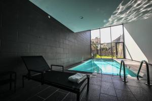 a swimming pool in a room with a chair and a chair at Hotel da Fábrica in Manteigas