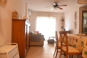 sala de estar con mesa y ventilador de techo en Apartment Jardines Del Mar, en La Manga del Mar Menor