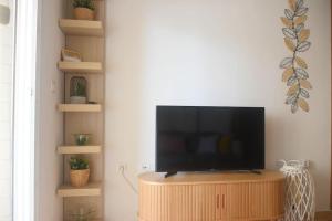 a flat screen tv sitting on a wooden stand in a room at Apartment Jardines Del Mar in La Manga del Mar Menor