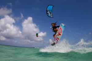 a woman riding a wave on a surfboard in the ocean at Posada Guaripete in El Roque