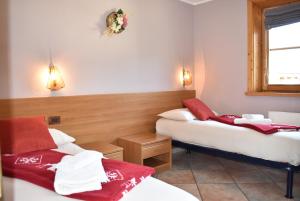 リヴィーニョにあるAppartamento Trela 3のベッド2台(赤と白のタオル付)が備わる客室です。