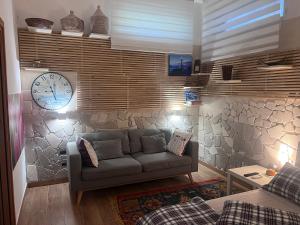 a living room with a couch and a clock on a wall at tulipano rosso in Bari