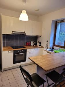 een keuken met witte kasten en een tafel met stoelen bij relais du 21 in Saint-Germain-en-Laye