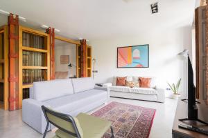 a living room with a white couch and a chair at apartamento reformado estilo industrial plaza de tirso de molina in Madrid