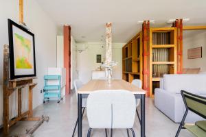 a dining room with a table and chairs and a couch at apartamento reformado estilo industrial plaza de tirso de molina in Madrid