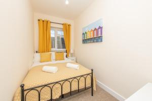 a bedroom with a bed with yellow curtains at Sutton Cottage - 4BR 2Bath House Up to 9 Guests - Smart TV - Huge Bedrooms - Ideal for Contractors in Southampton +16 photos