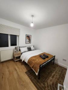 a bedroom with a large bed with a wooden floor at Beautiful 3 bed house in Hartford in Hartford