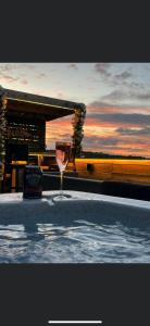 a glass of wine sitting next to a swimming pool at Tan Y Bryn Glamping in Conwy