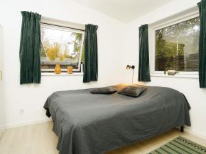 a bedroom with a bed and two windows at Holiday home Gilleleje CVII in Gilleleje