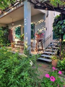 a porch of a house with a staircase and flowers at Casa Cambini in Marina di Massa