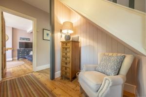 une pièce avec une chaise et une commode avec une lampe dans l'établissement Porch House, à Hunstanton