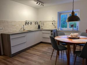 eine Küche mit einem Tisch und einem Esszimmer in der Unterkunft Home of gmiatlich - Ferien & Wohnen auf Zeit in Mühldorf