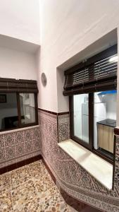 een keuken met een raam en een betegelde muur bij Apartamento Doble Vacacional Carmona in Carmona