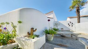 eine Terrasse mit einer Bank und einigen Pflanzen in der Unterkunft Charmante villa avec piscine in La Couarde-sur-Mer