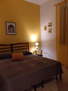 1 dormitorio con 1 cama y 1 mesa con lámpara en Belvedere in Villa Greco, en Tindari