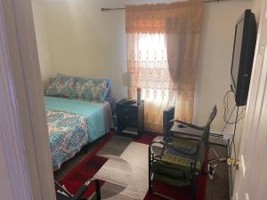 ein Schlafzimmer mit einem Bett, 2 Stühlen und einem TV in der Unterkunft Mo Short Term Rentals in Mount Vernon