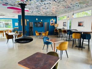 a restaurant with a fireplace and tables and chairs at Côté Océan Resort in Angoulins-sur-Mer