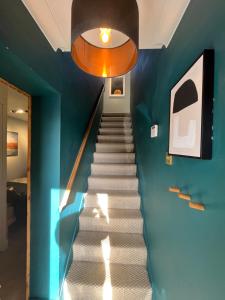 a staircase in a house with a blue wall at The Coachhouse, Hot Tub in Henley in Arden