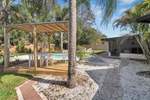 einen Hinterhof mit einem Holzpavillon und einem Pool in der Unterkunft Private Pool Home Centrally Located in Tampa in Tampa