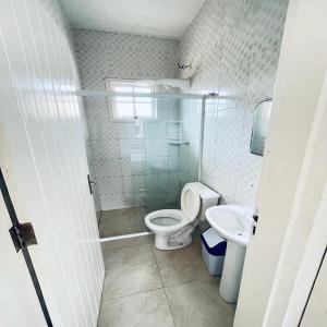 bagno con servizi igienici e lavandino di Carpi Apartamentos Ubatuba a Ubatuba