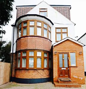a large brick house with a wooden door at Extra Large, Modern Family Home in Finchley London Close to Station and Central London in Finchley