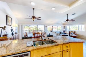 a kitchen with a sink and a living room at Canal-side Charisma in Key Colony Beach