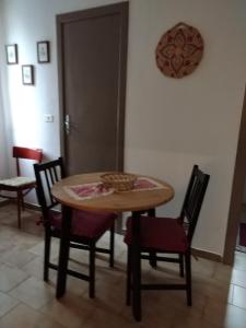 una mesa y sillas en una habitación con puerta en Belvedere in Villa Greco, en Tindari