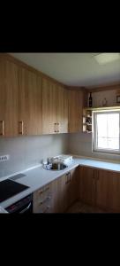 a kitchen with wooden cabinets and a sink and a window at Vikendica Rosi 